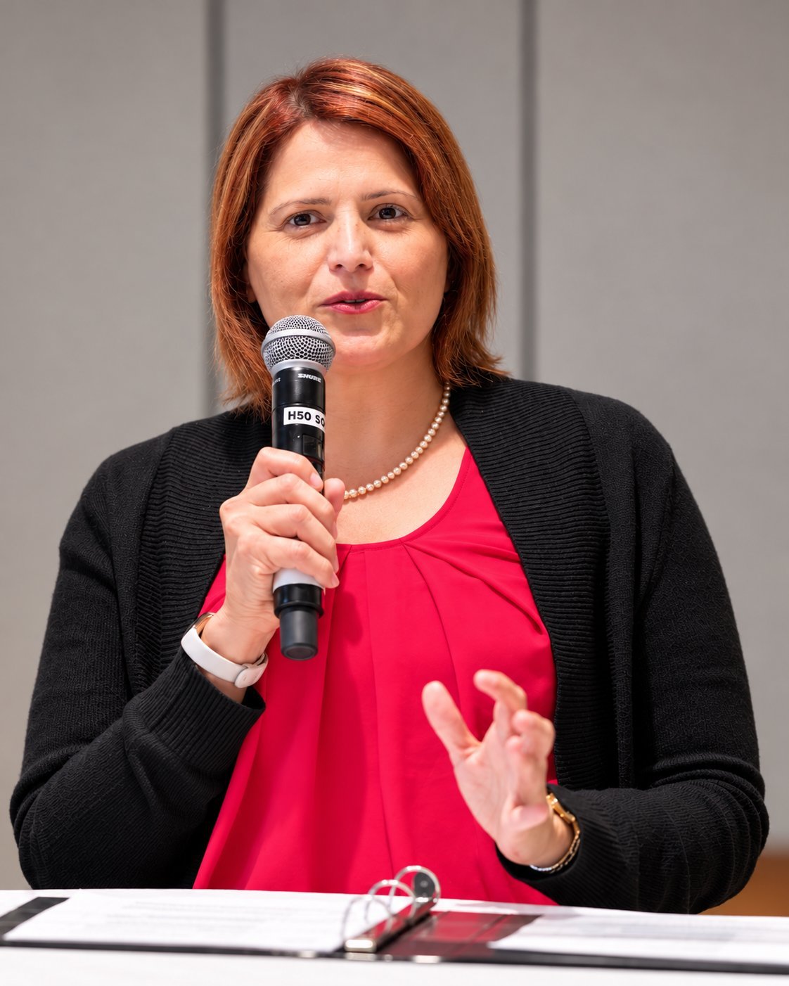 Maliha Aqeel speaking with a microphone